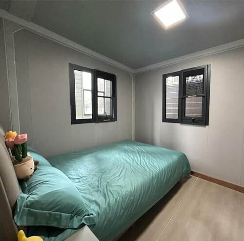 Minimalist bedroom with teal bedding and small windows.